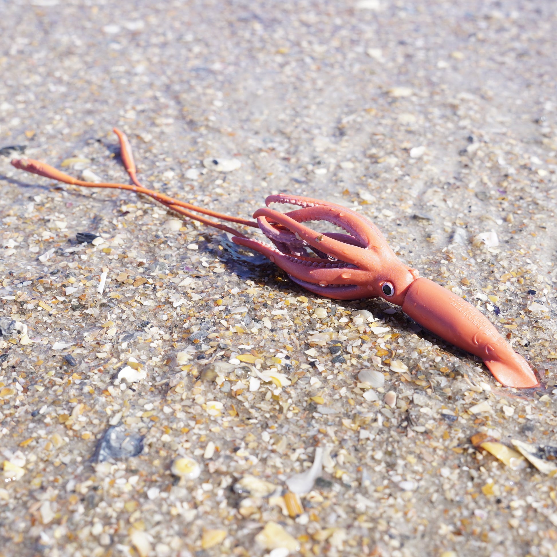 Safari Ltd Giant Squid figurine on sandy beach